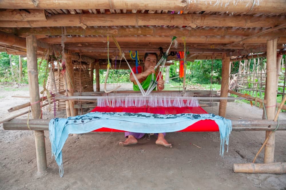 Artisan weaver verifying textile quality